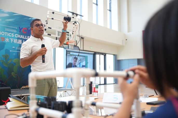 Student receiving guidance from underwater robotics expert