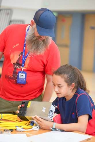 Student and mentor examining underwater robotics device