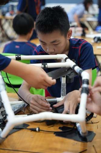 Young student working on underwater robotics project assembly