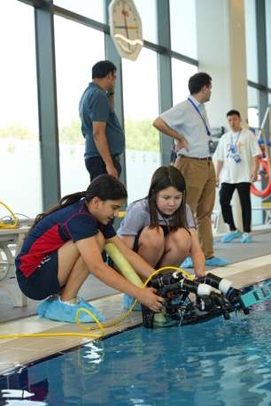 Students testing underwater robotics in pool environment