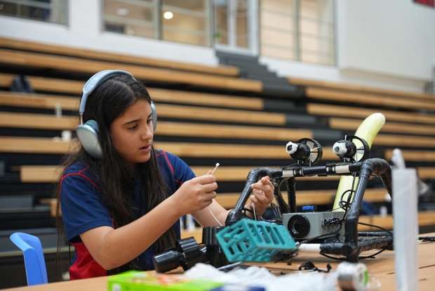 Student wearing headphones while programming underwater robot