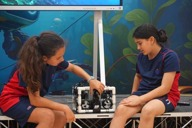 Female students collaborating on underwater robotics project