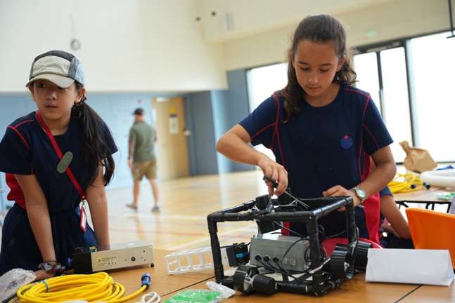 Girls team working on underwater robot programming and assembly