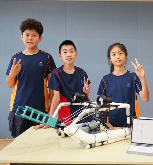 Winning students posing with underwater robotics competition achievements