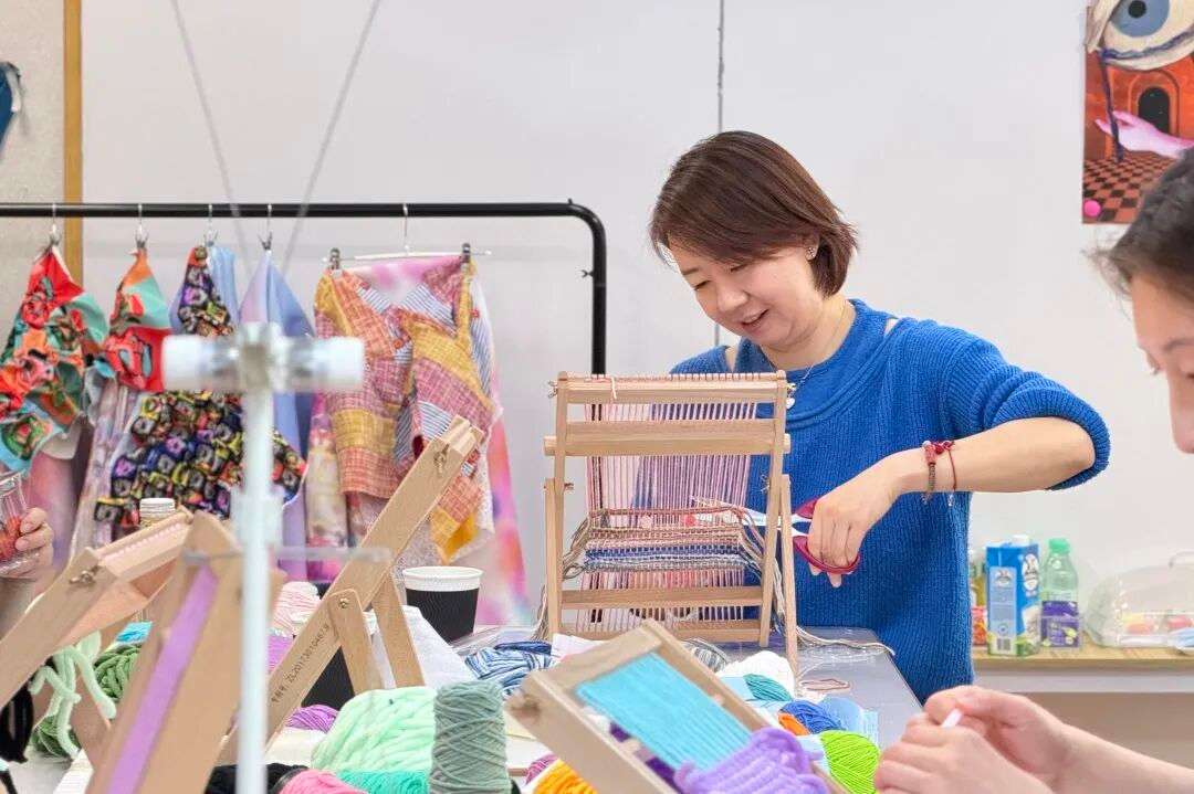 参与者挑选彩色纱线进行图案编织，家校共育氛围浓厚