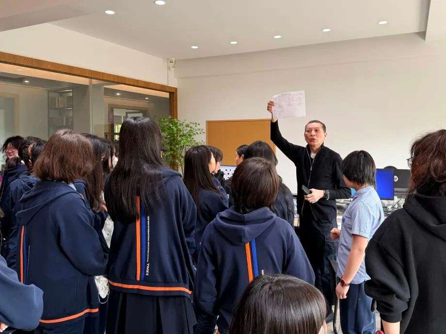 工厂师傅演示细节工艺，学生近距离观察提问（时尚教育实践）